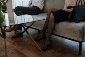 A man and woman sitting on opposite ends of a sofa