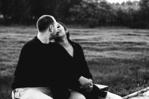 A couple about to kiss in front of a field