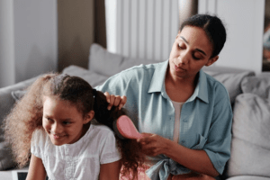 A mother combing curly hair